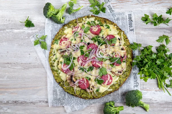 Salam ile Crust Brokoli baz düşük karbonhidrat keto pizza, vintage newspapper avokado. Üstte görüntü