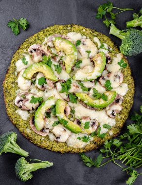 Avokado, peynir ile yeşil brokoli hamur kabuk pizza. Düşük karbonhidrat, kayrak arka plan üst görünümünde ketojenik diyet vegan vejetaryen pizza