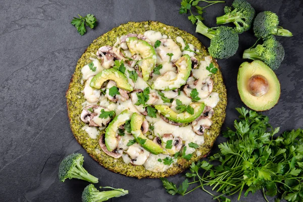 Avokado, peynir ile yeşil brokoli hamur kabuk pizza. Düşük karbonhidrat, kayrak arka plan üst görünümünde ketojenik diyet vegan vejetaryen pizza
