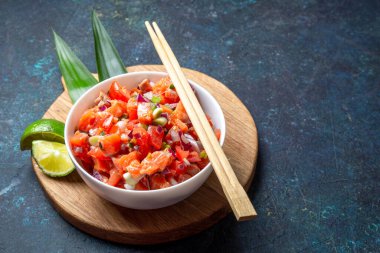 Lomi somonu, Hawaii çiğ somon salatası mavi arka planda..
