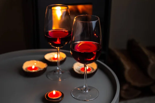 Два бокала красного вина перед камином. Романтический свет — стоковое фото