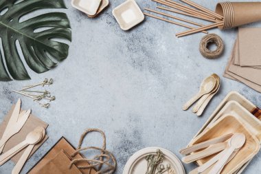 Eko kağıt ve ahşap sofra takımı. Kağıt bardaklar, tabaklar, çanaklar, tabaklar ve gri arka planda bambu çatal bıçak takımı. Geri dönüşüm veya çevre dostu konsept, Üst Görünüm, Boşluğu Kopyala
