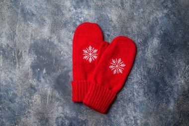 Noel ve yeni yıl kompozisyonu atkıyla, kadın eldiveni ile, sıcak içecekle bardaklar ve gri beton arka planda lokum. Düz yatış, üst görünüm.