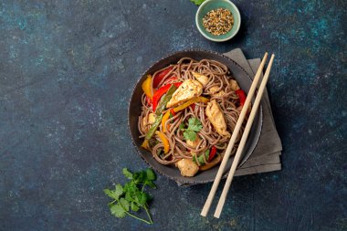 Japon karabuğdaylı soba şehriyesi tavuk ve sebzeli havuç, dolma biber ve yeşil fasulye gri kasede, üst manzara, kopyalama alanı