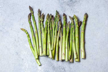 Gri arkaplanda taze yeşil kuşkonmaz. Üst görünüm kopyalama alanı.