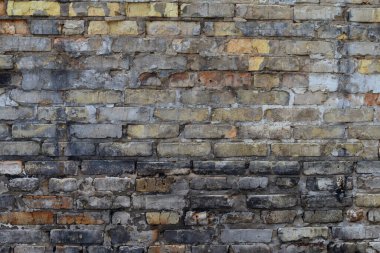 Old weathered brick wall background with cracked and discolored surface, symbolizing decay, vintage architecture, urban texture, grunge design, construction and industrial concepts