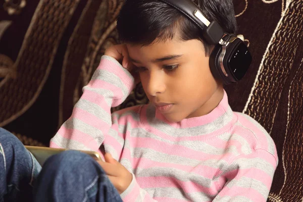 Indian young boy listen music with headphone