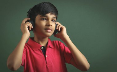 Hintli çocuk, kulaklıkla müzik dinle.