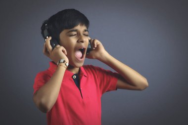 Hintli genç çocuk kulaklıkla bağırıyor