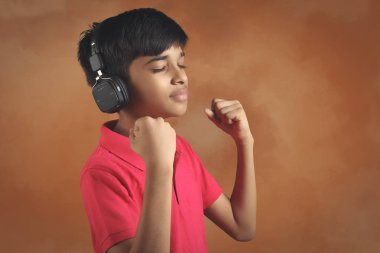 Hintli çocuk, kulaklıkla müzik dinle.
