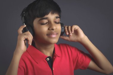 Hintli çocuk, kulaklıkla müzik dinle.