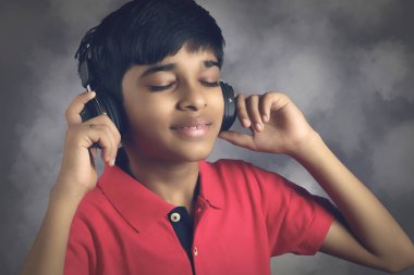 Hintli çocuk, kulaklıkla müzik dinle.