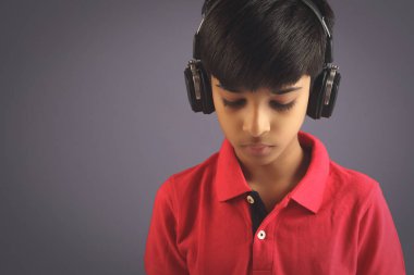 Hintli çocuk, kulaklıkla müzik dinle.