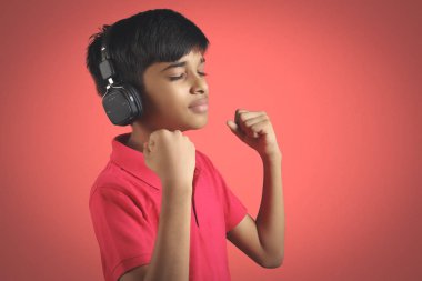 Hintli çocuk, kulaklıkla müzik dinle.