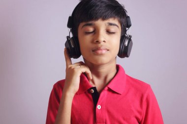 Hintli çocuk, kulaklıkla müzik dinle.