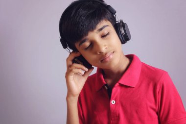 Hintli çocuk, kulaklıkla müzik dinle.