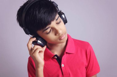 Hintli çocuk, kulaklıkla müzik dinle.