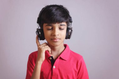 Hintli çocuk, kulaklıkla müzik dinle.