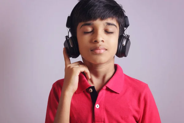 インドの少年はヘッドフォンで音楽を聴く — ストック写真