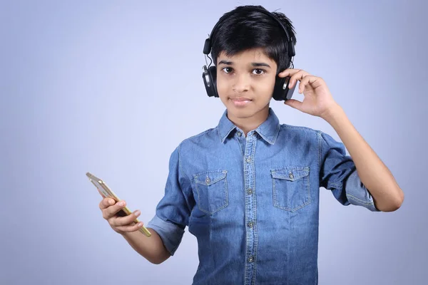 Indian Young Boy Listen Music Headphone Holding Mobilephone —  Fotos de Stock