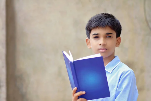 Kameraya poz veren Hintli küçük okul çocuğunun portresi.