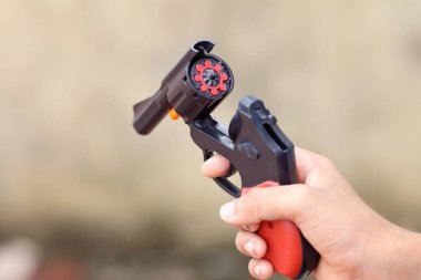 Küçük çocuk oyuncak tabancayı Diwali 'ye doğrultuyor.