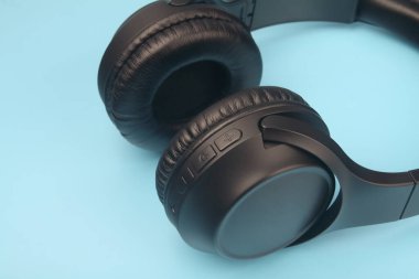 Mavi arka planda izole edilmiş profesyonel kablosuz kulaklıklar.