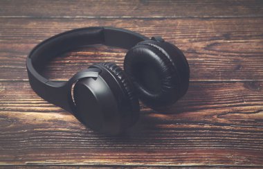 Ahşap masaya izole edilmiş modern profesyonel kulaklıklar.