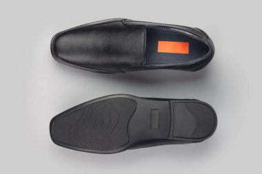 Gri arka planda siyah deri şık ayakkabılar.