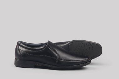 Gri arka planda siyah deri şık ayakkabılar.