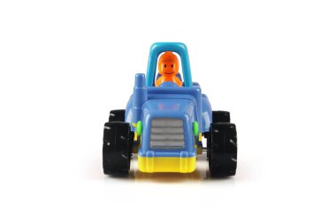 Beyaz arka planda römorku olan oyuncak traktör modeli