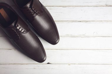 Erkeklerin resmi deri ayakkabıları ahşap masada izole edilmiş.