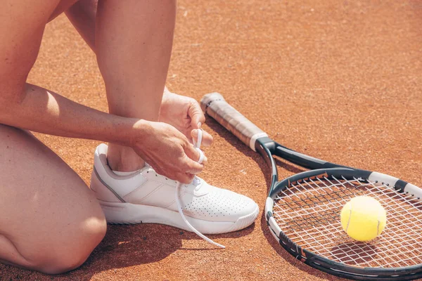 Professionell kvinna tennisspelare binda skosnören innan hennes tennis match eller tävling, sport koncept, copyspace — Stockfoto