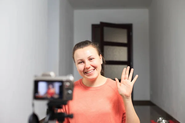 Ung kvinnlig bloggare spela in en video för sina abonnenter med en professionell kamera, vlog — Stockfoto
