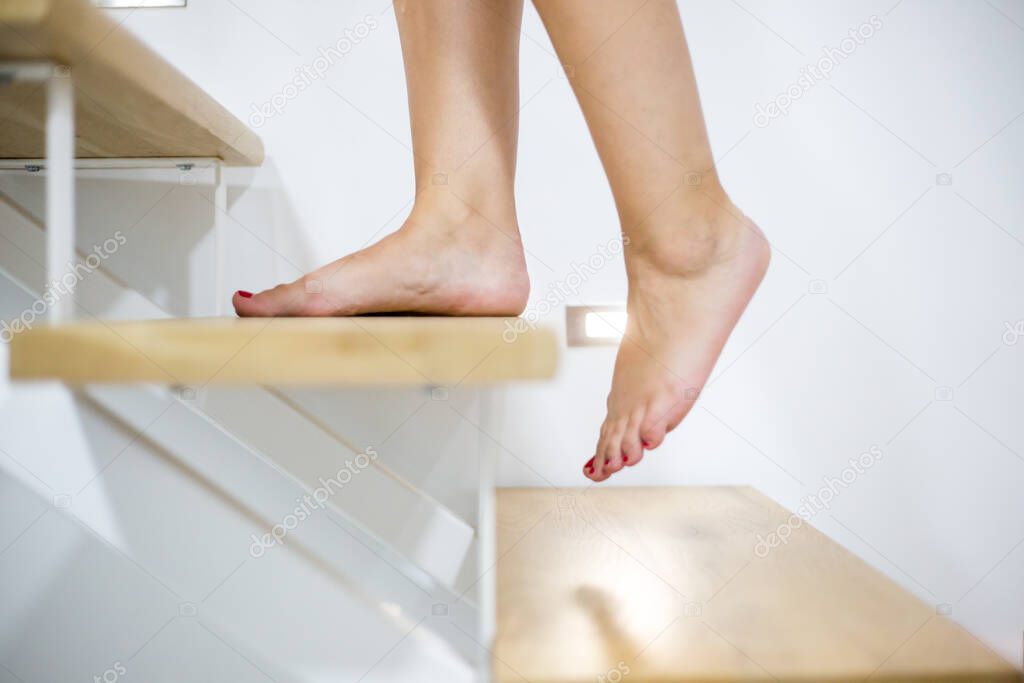 Young woman feets on the wood stairs, lifestyle