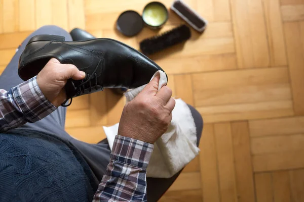 Man hands cleaning his shoes with a rag and shoe wax fot better condition of his shoes, polishing shoes Stock Picture