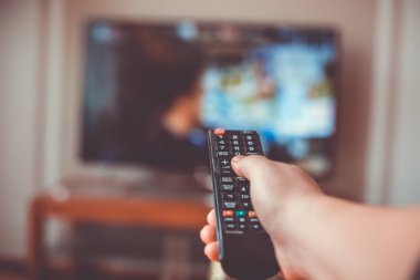 Uzaktan kumandalı televizyonla el sıkışın ve düğmeye basın, teknoloji konsepti