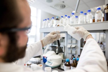 Laboratuvarda araştırma yapan insan araştırmacılarının elleri. Yeni bir ilaç ve kimya konseptini araştırıyorlar.