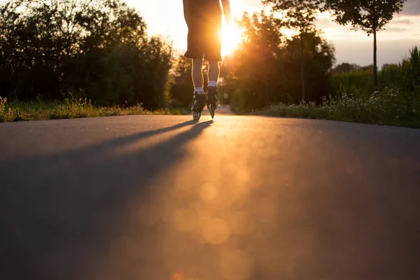 Jeune homme profitant du patin à roulettes sur la piste cyclable pendant le beau coucher de soleil d'été, style de vie et concept sportif — Photo