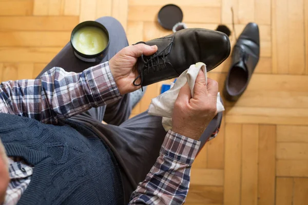 Man hands cleaning his shoes with a rag and shoe wax fot better condition of his shoes, polishing shoes Stock Image