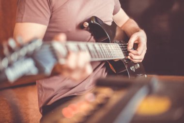 Profesyonel, siyah elektro gitar, müzik aleti, eğlence, yaşam tarzı çalan genç adamın elini kapatıyoruz.