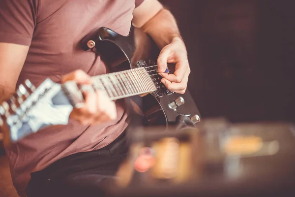 Close up hand of young man playing on a professional, black electric guitar, music instrument, entertainment, lifestyle — Stock Photo, Image