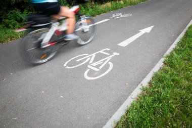 Motosikletli bisikletçi, hızlı giden bisiklet yolu, hareket bulanıklığı tekniği hareket ve yaşam tarzı konseptini iletmek için kullanılır.