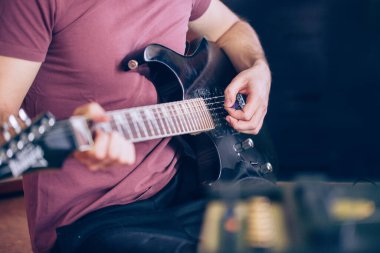 Profesyonel, siyah elektro gitar, müzik aleti, eğlence, yaşam tarzı çalan genç adamın elini kapatıyoruz.