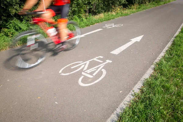 Cyklist på väg cykel, cykelväg går snabbt, rörelse suddig teknik används för att förmedla rörelse, livsstil koncept — Stockfoto