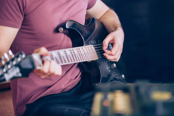 Close up hand of young man playing on a professional, black electric guitar, music instrument, entertainment, lifestyle — Stock Photo, Image