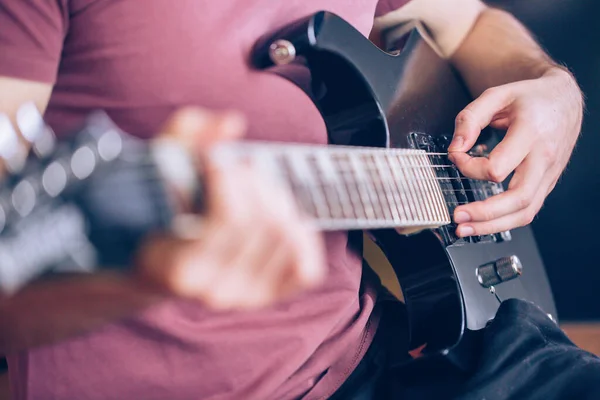 Close up hand of young man playing on a professional, black electric guitar, music instrument, entertainment, lifestyle — Stock Photo, Image