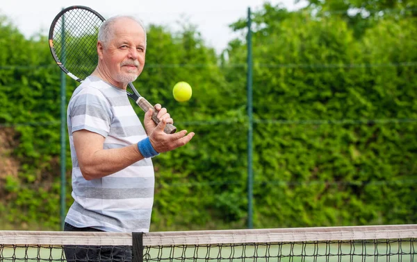 Porträtt av senior man som spelar tennis utanför, pensionerad sport, sport koncept — Stockfoto