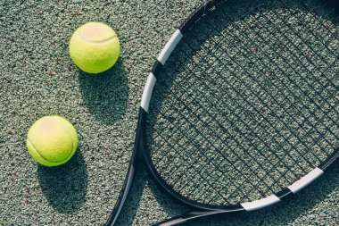 Tenis raketi ve topların yakın görüntüsü kil tenis kortunda, eğlence sporu