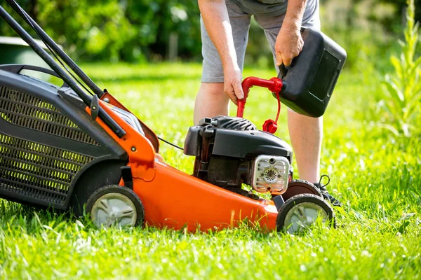 Man refueling the lawnmower on his huge garden, gardening concept — Stock Photo, Image